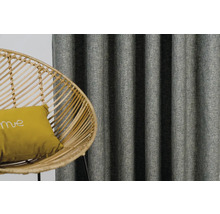 Dekorativní závěsy a ratanové křeslo s polštářem v obývacím pokoji