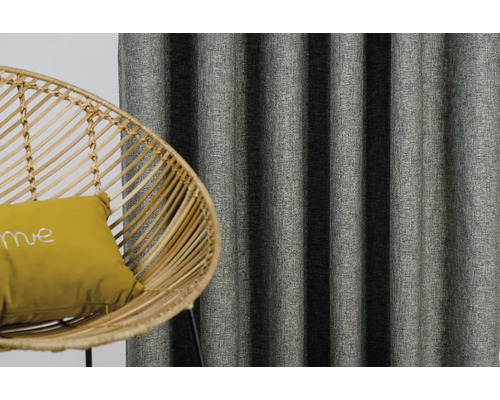 Dekorativní závěsy a ratanové křeslo s polštářem v obývacím pokoji