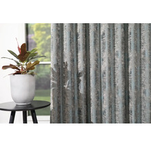 Dekorační šály se strukturovaným vzorem vedle hrnkové rostliny na malém stole