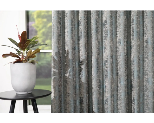 Dekorační šály se strukturovaným vzorem vedle hrnkové rostliny na malém stole