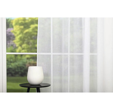 Okno s bílým závěsem a váza na příručním stolku