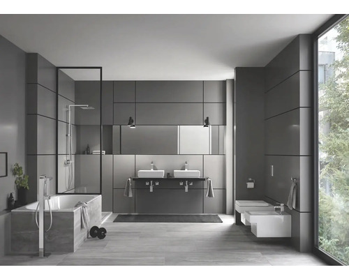 Moderní koupelna s vanou, sprchou, dvojitým umyvadlem a toaletou.