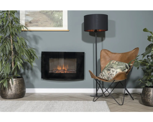 Obývací pokoj s elektrickým krbem, stojací lampou, křeslem a pokojovými rostlinami pro útulnou atmosféru