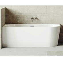 Obdélníková vana ze sanitárního akrylátu s armaturami na betonové stěně