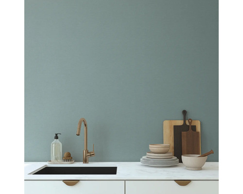 Kuchyňský dřez s baterií, mycí prostředek, nádobí a krájecí desky na pracovní desce