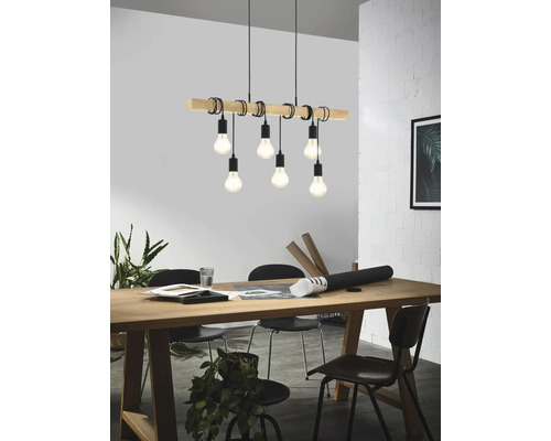 Závěsné svítidlo s dřevěným trámem a šesti žárovkami nad jídelním stolem.