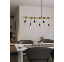 Dřevěné závěsné svítidlo s několika žárovkami nad jídelním stolem.