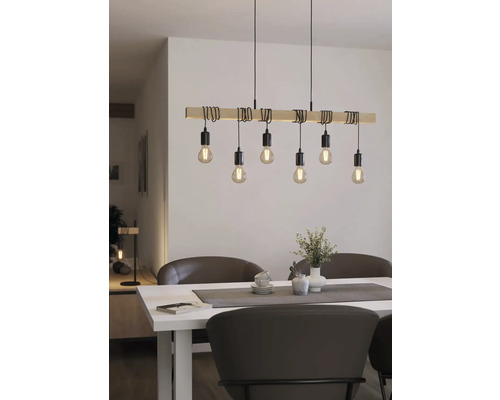 Dřevěné závěsné svítidlo s několika žárovkami nad jídelním stolem.