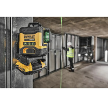 Logo DeWalt 18voltová akumulátorová laserová vodováha se zelenými laserovými liniemi ve stavebním prostředí.