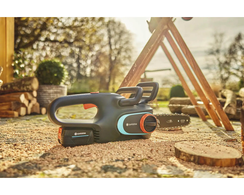 Akumulátorová řetězová pila Gardena s akumulátorem ležícím na zemi