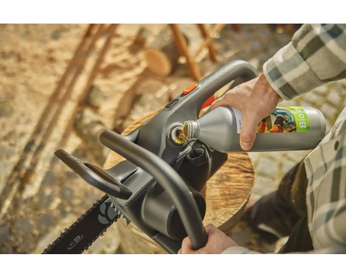 Osoba plní řetězovou pilu olejem