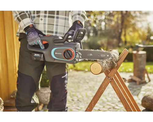 Akumulátorová řetězová pila Gardena s dřevěným kmenem na kozě