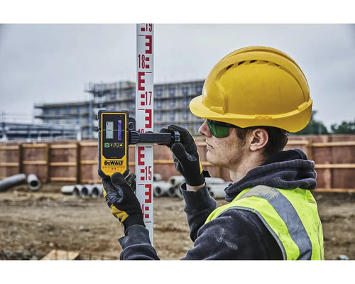 Stavební dělník s laserovým dálkoměrem DeWalt na nivelační lati