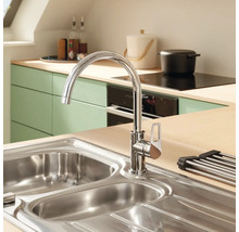 Kuchyňský dřez s vodovodní baterií ve světlé kuchyni.