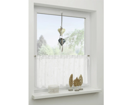 Zdobené okno s přívěskem ve tvaru srdce, záclonou a dekorací okenního parapetu