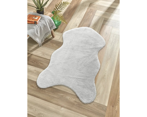 Dekorativní koberec ve vzhledu kožešiny na dřevěné podlaze