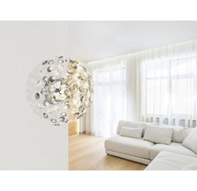 Moderní design obývacího pokoje s výrazným nástěnným svítidlem a světlou sedací soupravou.