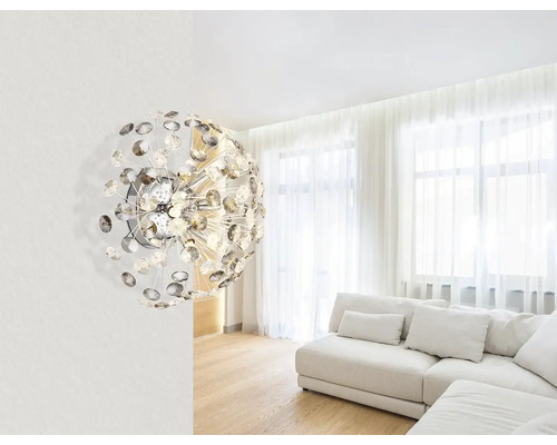 Moderní design obývacího pokoje s výrazným nástěnným svítidlem a světlou sedací soupravou.