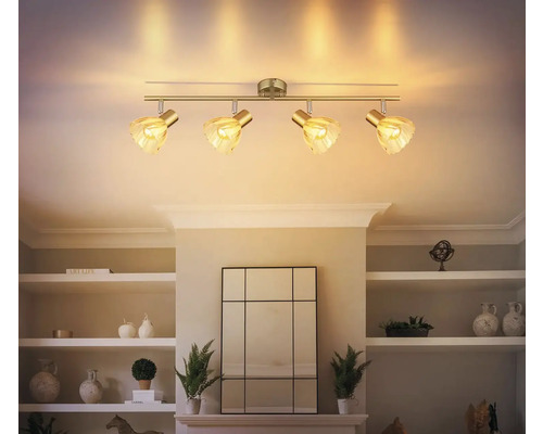 Stropní svítidlo se čtyřmi reflektory a skleněnými stínidly namontované na stropě obývacího pokoje.