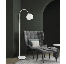 Elegantní stojací lampa vedle křesla a podnožky v obývacím pokoji