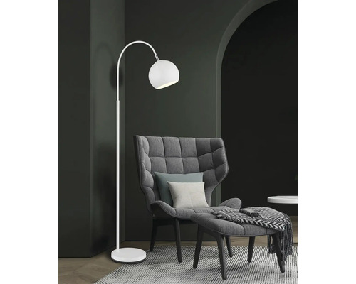 Elegantní stojací lampa vedle křesla a podnožky v obývacím pokoji