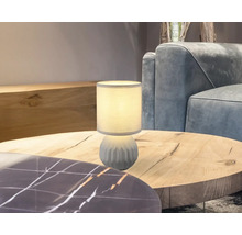 Dekorativní stolní lampa na dřevěném stole v obývacím pokoji.