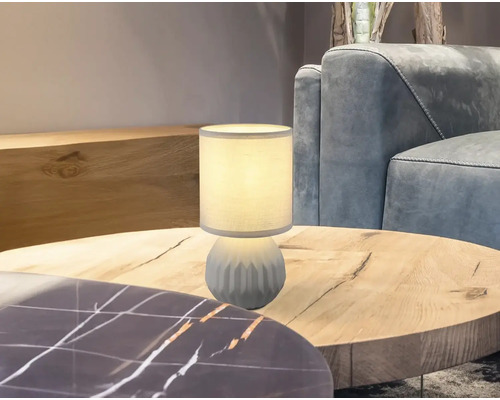 Dekorativní stolní lampa na dřevěném stole v obývacím pokoji.