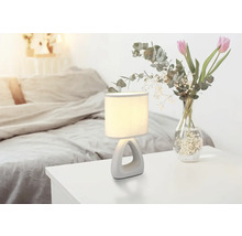 Noční lampa vedle kytice květin v ložnici