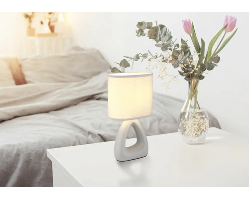 Noční lampa vedle kytice květin v ložnici