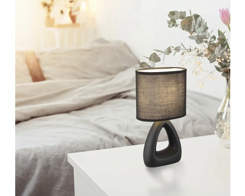 Dekorativní stolní lampa na nočním stolku v ložnici.