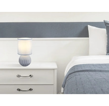Noční lampa na nočním stolku vedle postele