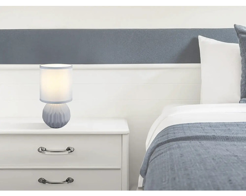 Noční lampa na nočním stolku vedle postele