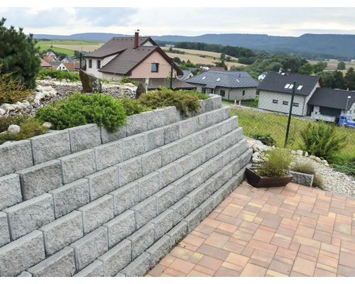 Terénní zahrada s opěrnou zdí z betonových bloků a dlážděnou terasou