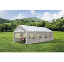 Bílý párty stan s okny a posezením na zeleném trávníku.