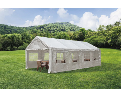 Bílý párty stan s okny a posezením na zeleném trávníku.
