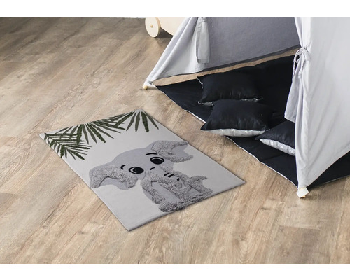 Herní pokoj s kobercem s motivem slona, hracím stanem a polštáři.