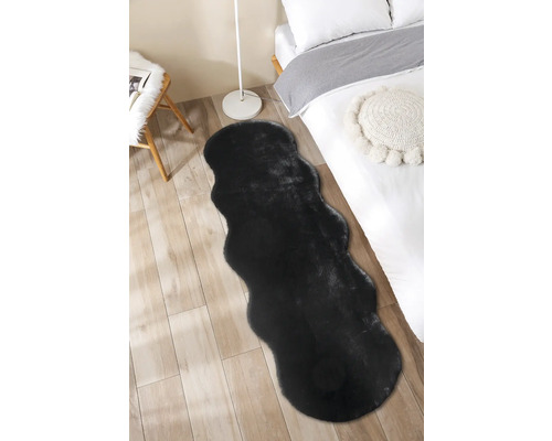 Černý koberec v ložnici na dřevěné podlaze