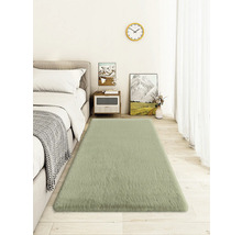 Ložnice s postelí, nočním stolkem, nástěnnými hodinami a obdélníkovým kobercem