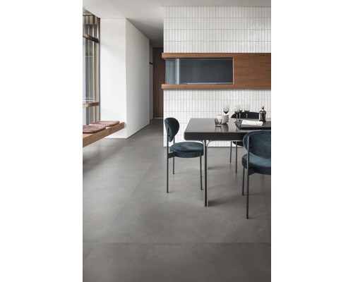 Světlá místnost s jídelním stolem a židlemi na šedé podlaze