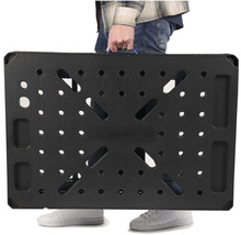 Osoba nese černý pracovní stůl s rukojetí