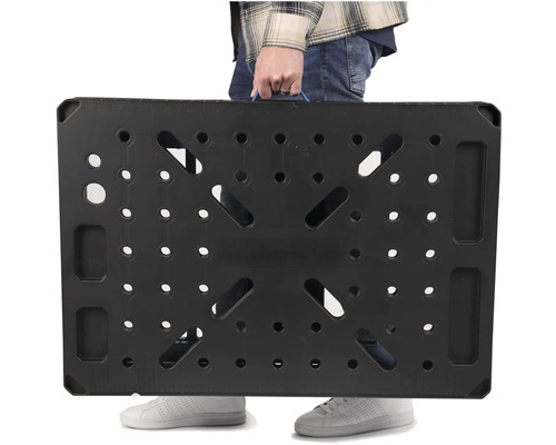 Osoba nese černý pracovní stůl s rukojetí