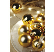 Dekorativní zlaté vánoční koule na talíři se světelným řetězem