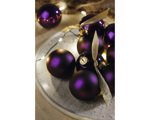 Dekorativní fialové vánoční koule s stuhami na talíři