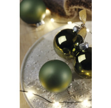 Dekorativní vánoční koule na talíři s umělým sněhem a světelným řetězem