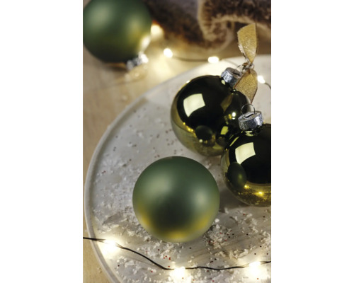 Dekorativní vánoční koule na talíři s umělým sněhem a světelným řetězem