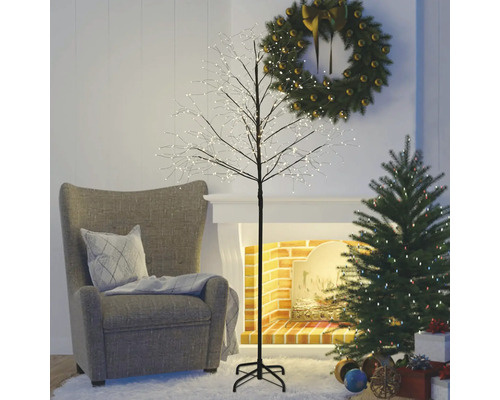 Obývací pokoj s křeslem, vánočním stromkem, adventním věncem a osvětleným ozdobným stromkem