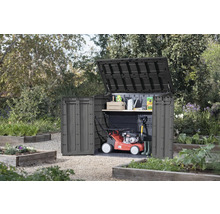 Zahradní skříň s otevřeným víkem a dveřmi na zahradě, s sekačkou na trávu a zahradním nářadím