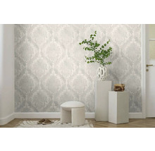 Světlá místnost se vzorovanou tapetou, malou stoličkou, dekorací a dveřmi