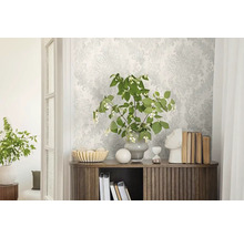 Světlý pokoj s vzorovanou tapetou, příborníkem a dekorativními prvky