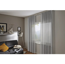 Obývací pokoj se záclonami, pohovkou a stojací lampou pro útulnou atmosféru